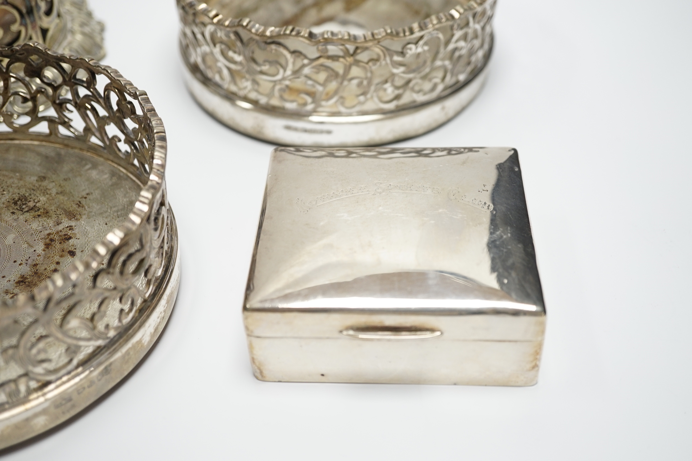 A George V silver cigarette case, 82mm, a similar silver mounted cigarette box, a modern silver mounted small wine coaster and three silver plated wine coasters including a pair.